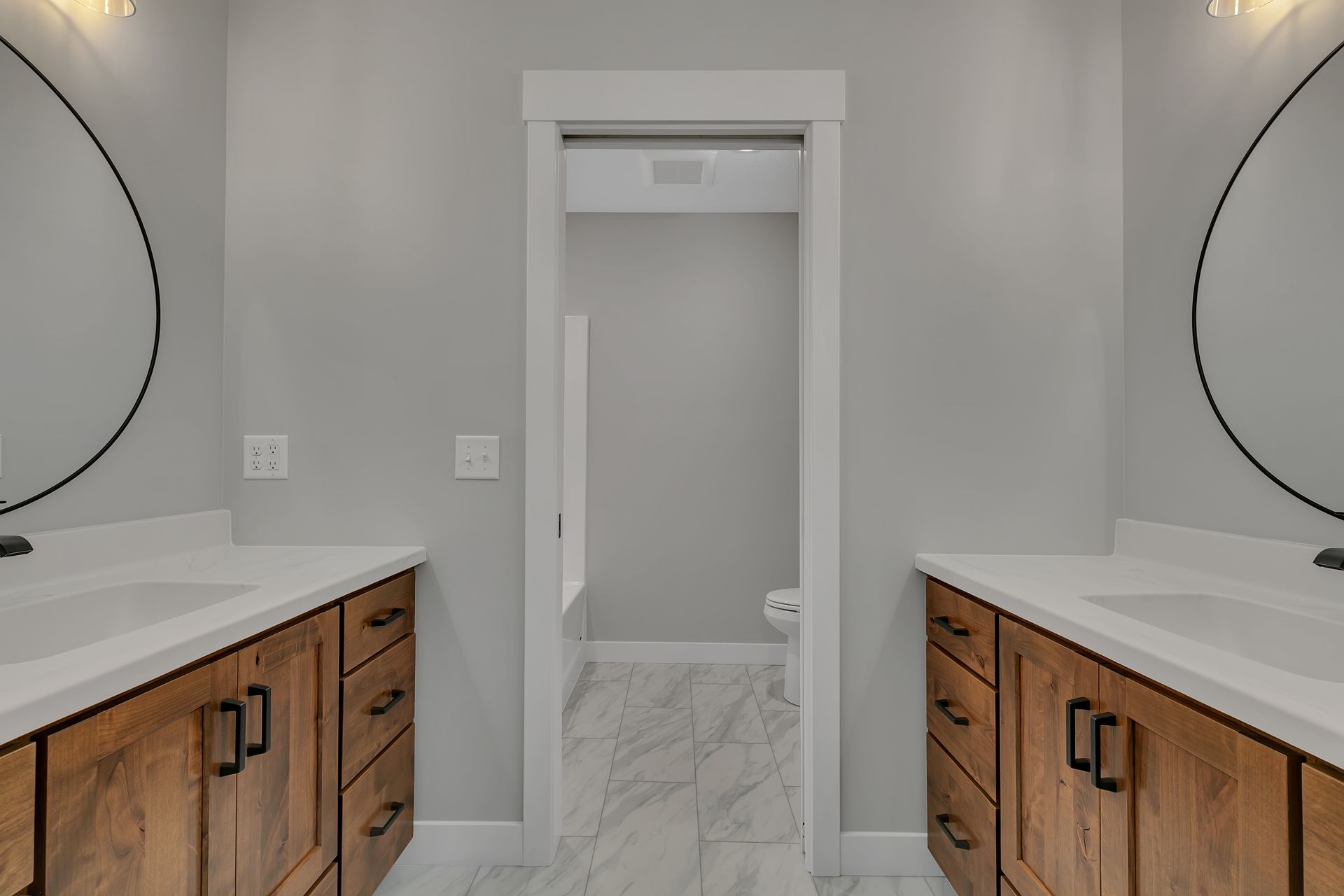A bathroom with two sinks and two mirrors.