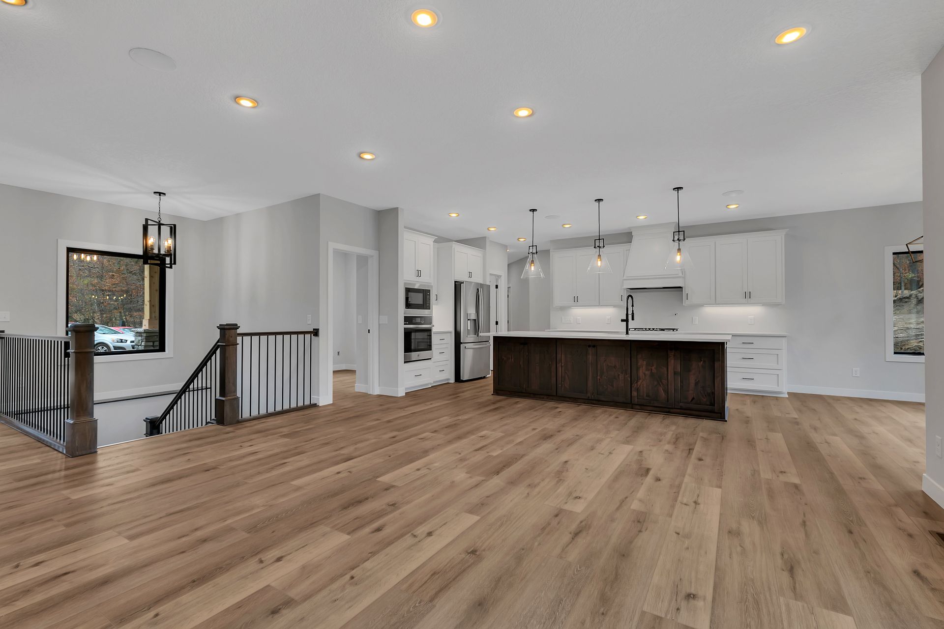 A kitchen with hardwood floors and white cabinets in a house.