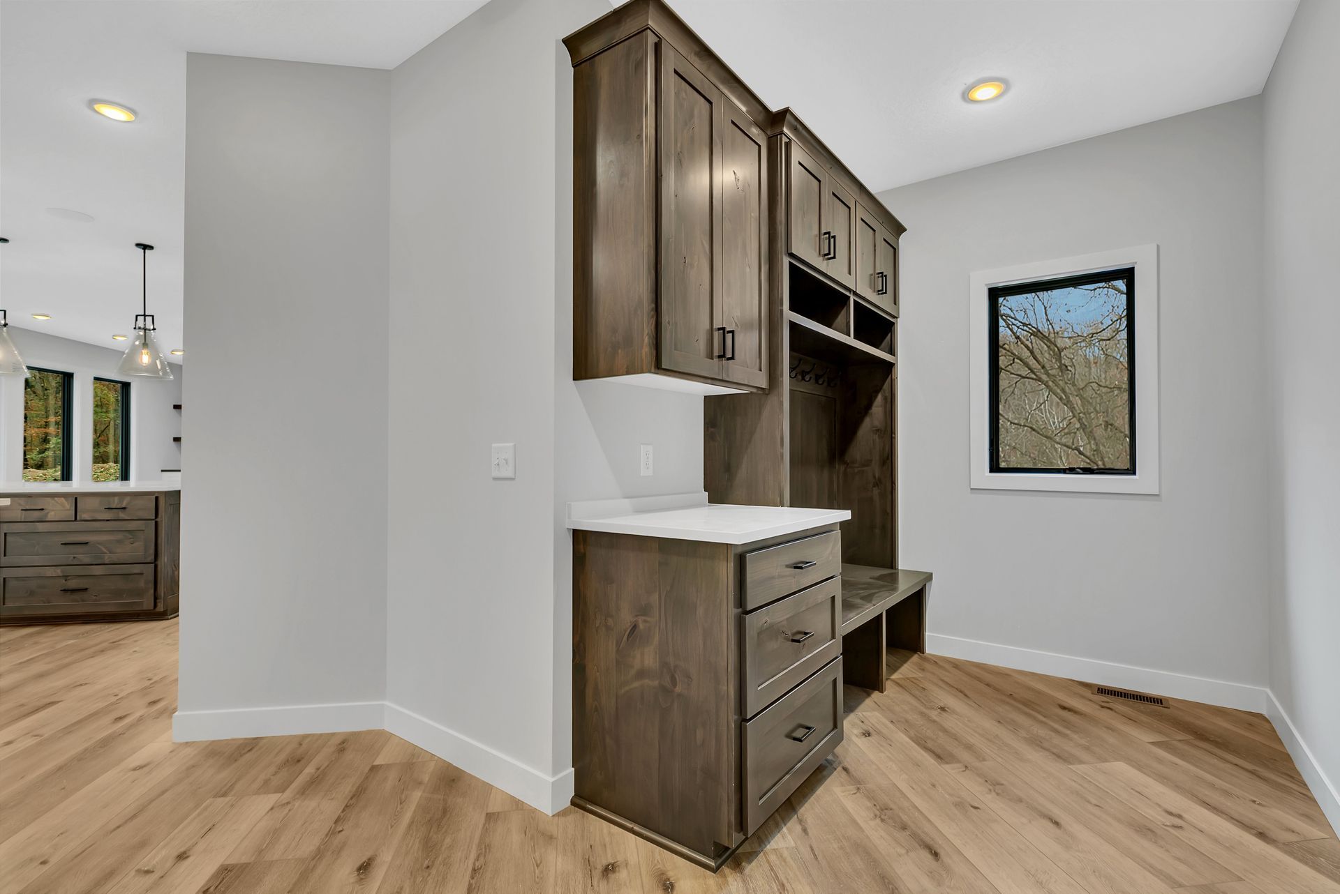 A room with wooden floors and cabinets and a window.