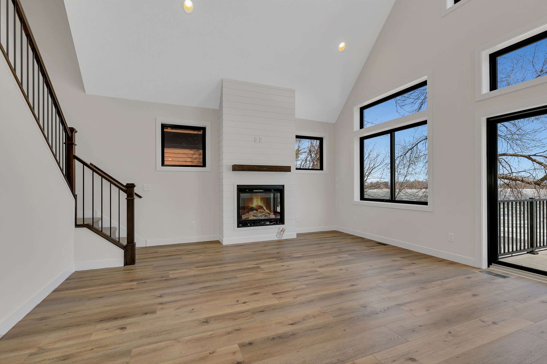 An empty living room with hardwood floors and a fireplace.