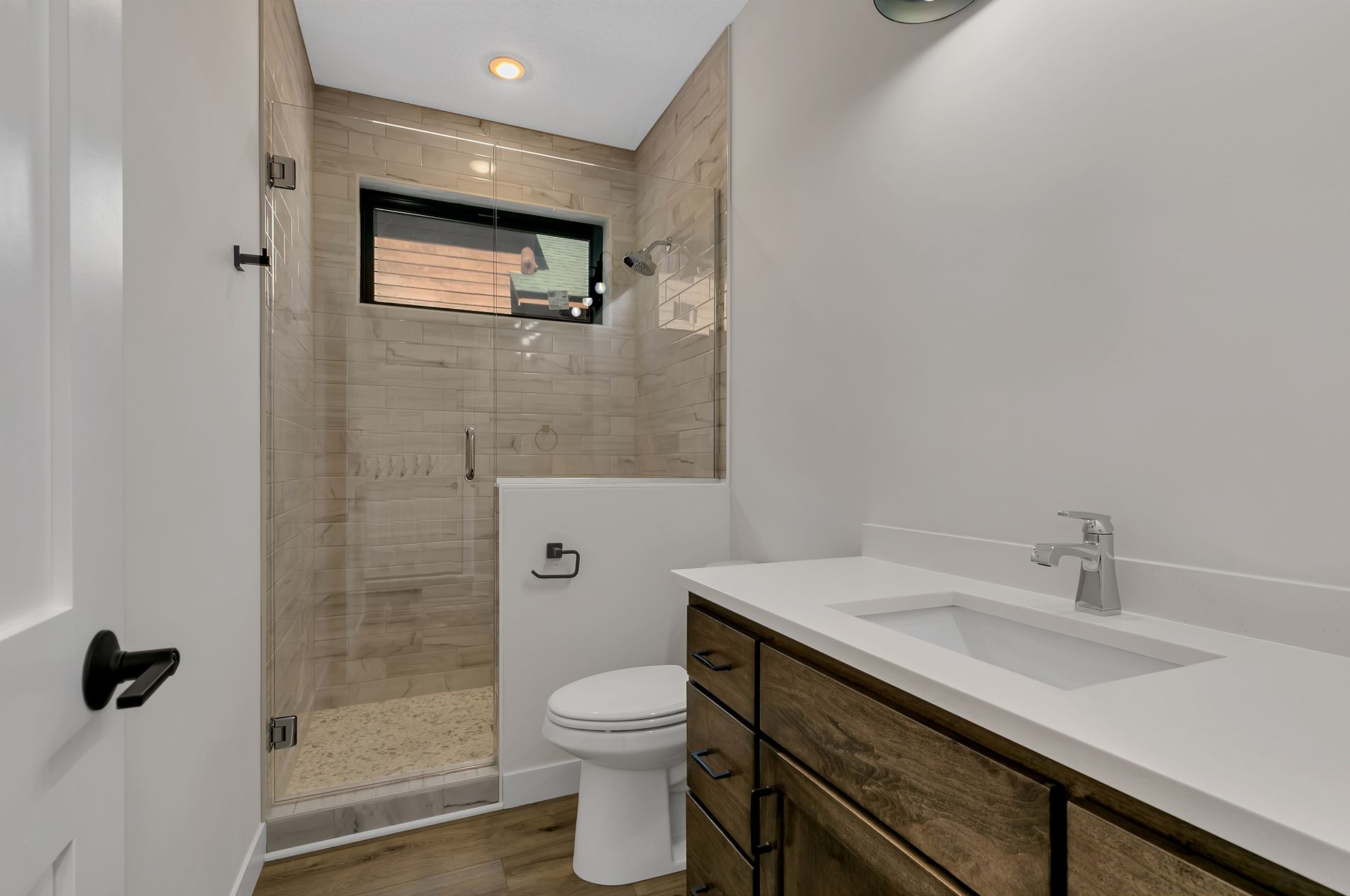 A bathroom with a toilet , sink , and walk in shower.