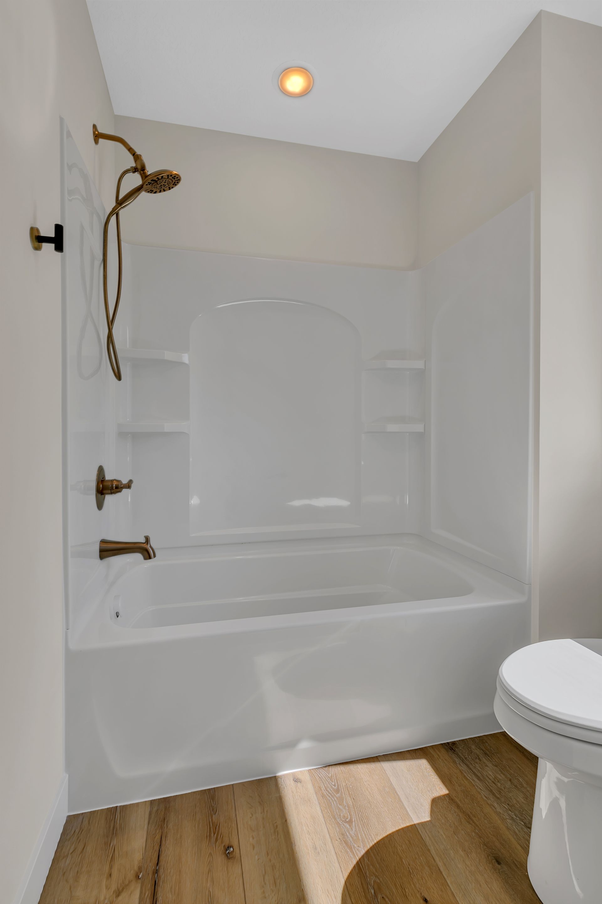 A bathroom with a tub , toilet and shower.