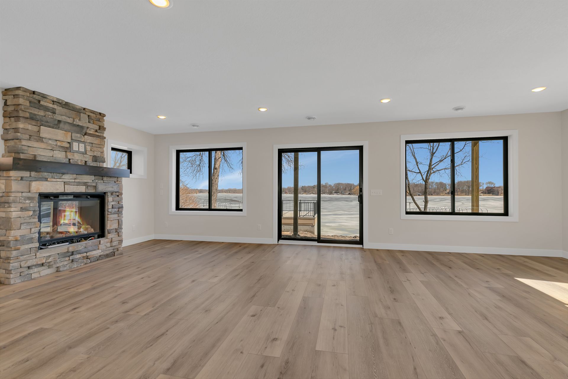 An empty living room with hardwood floors and a fireplace.