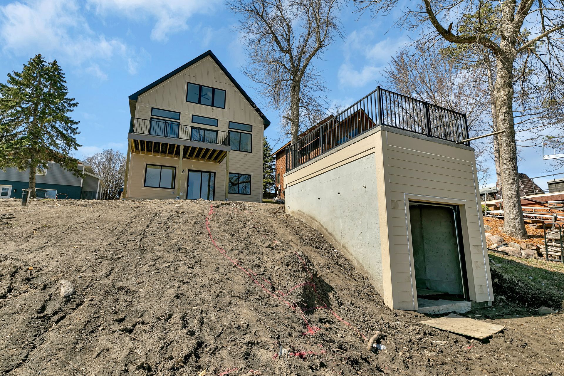 A building with a balcony is sitting on top of a dirt hill.