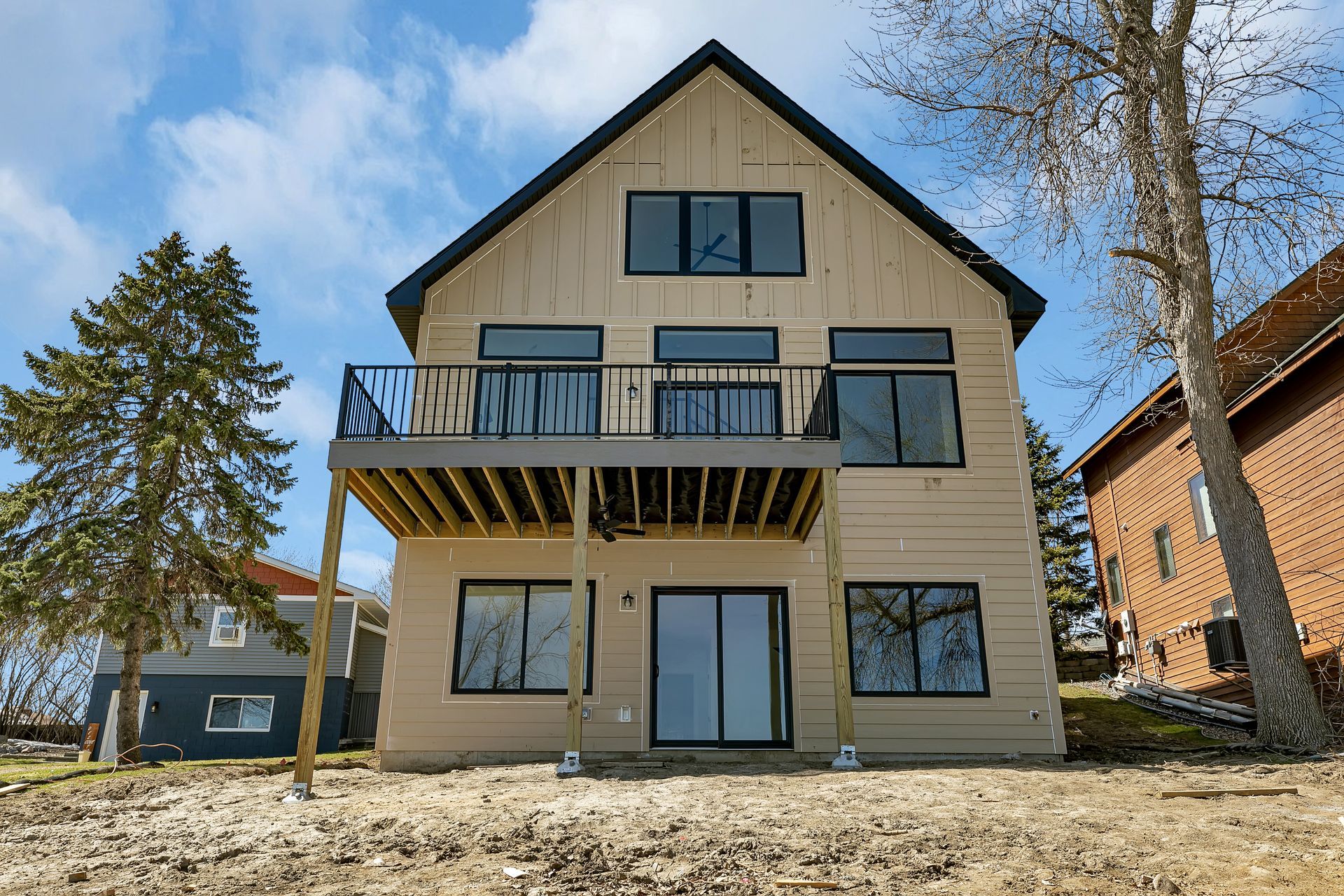 The back of a house with a balcony and a lot of windows.