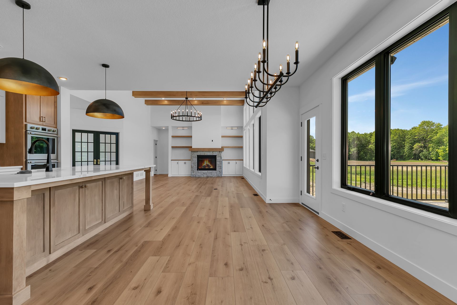 A large empty room with hardwood floors and a chandelier.