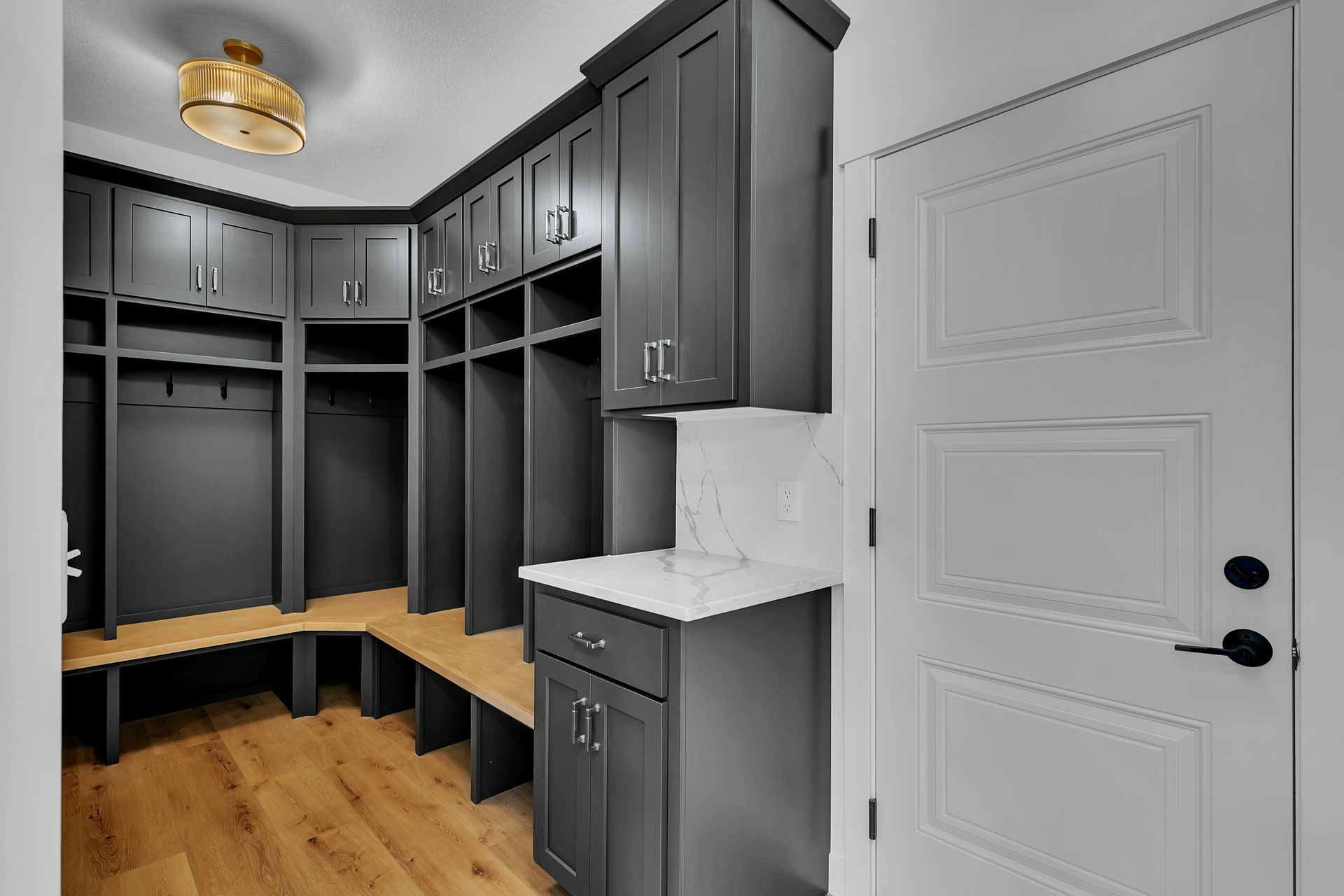 A mud room with lots of cabinets and a sink.