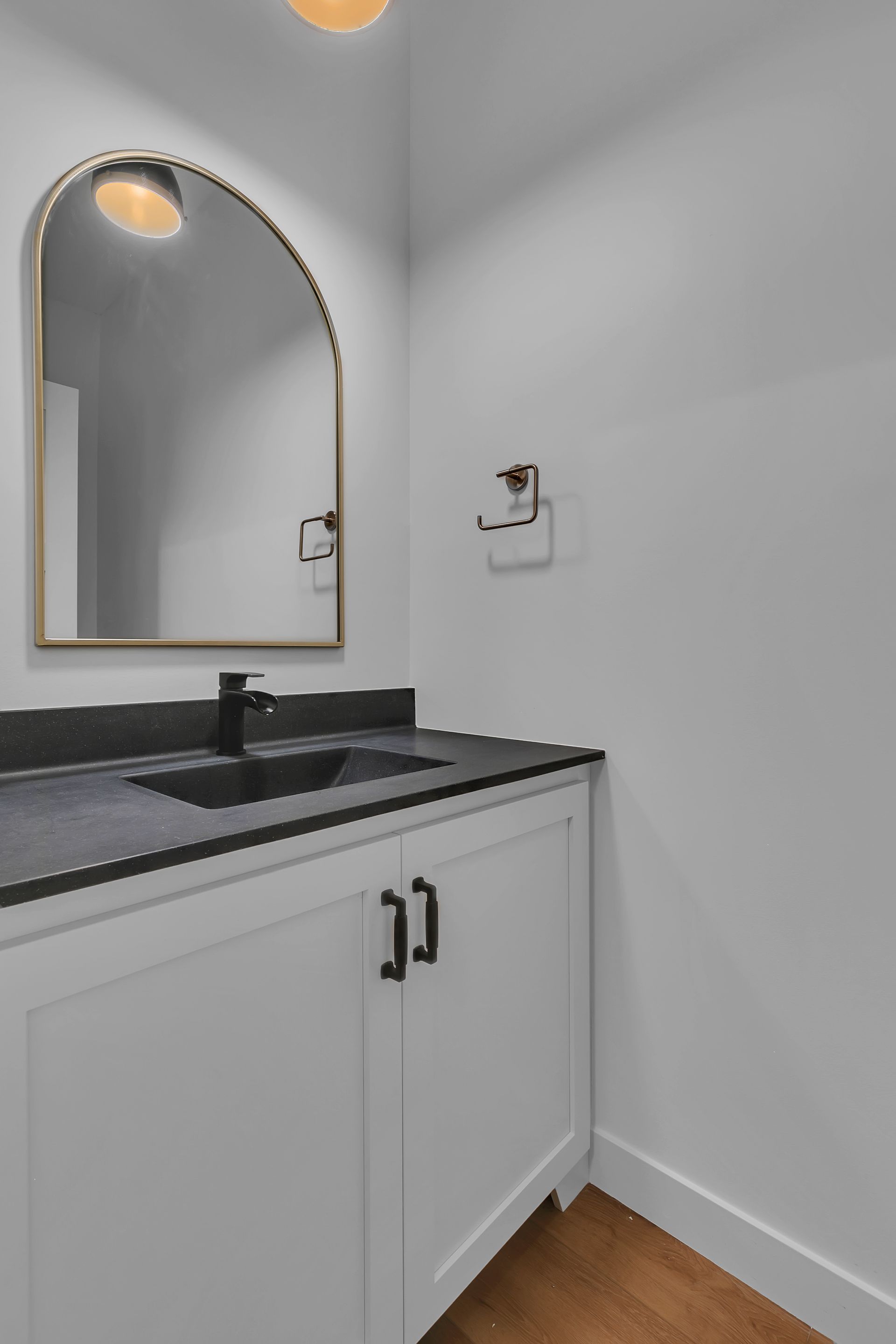 A bathroom with a sink , mirror and cabinets