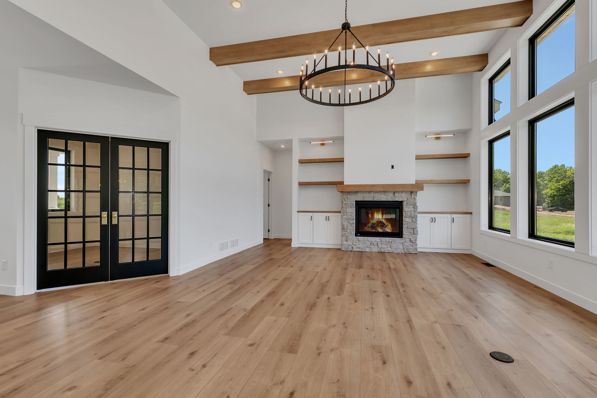 An empty living room with hardwood floors and a fireplace.