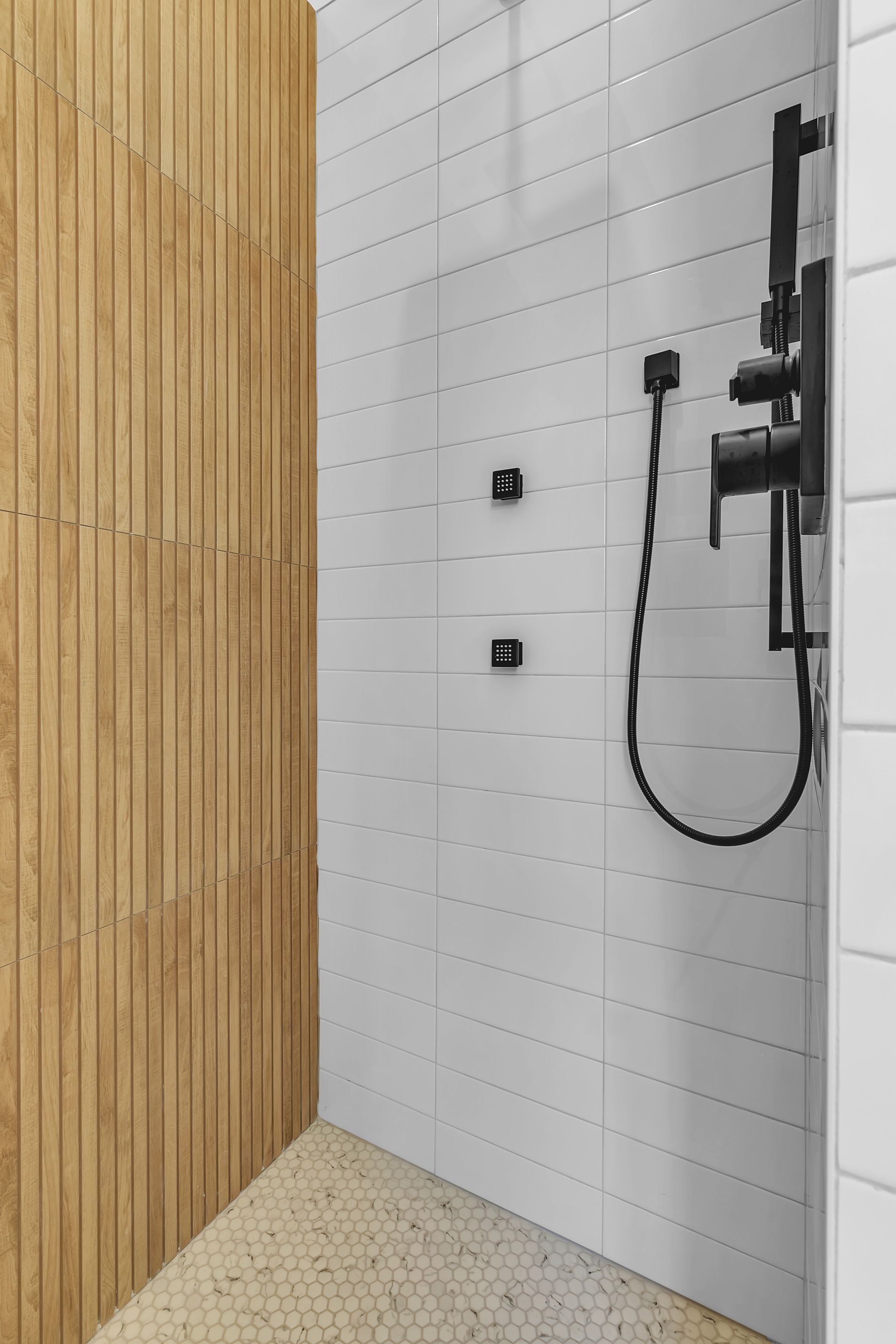 A bathroom with a shower and a wooden wall.