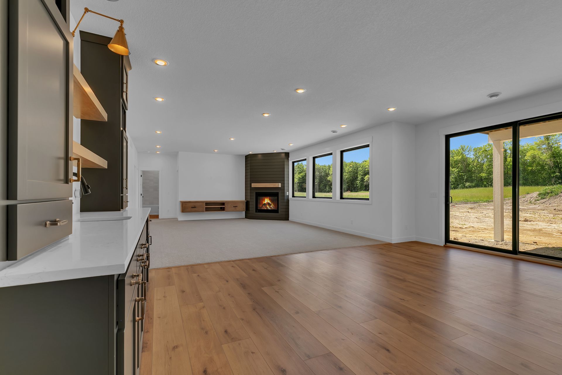 An empty living room with hardwood floors and a fireplace.