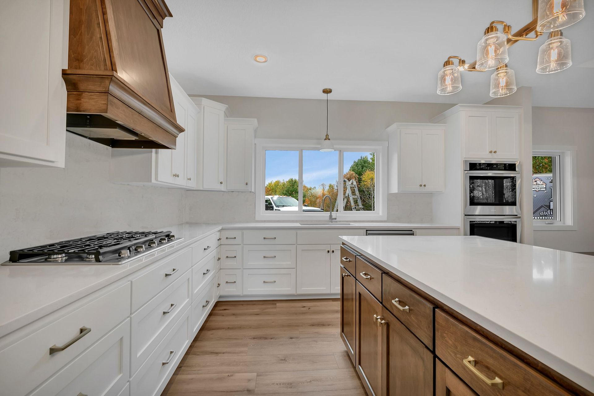 A kitchen with white cabinets , wooden cabinets and a large island.
