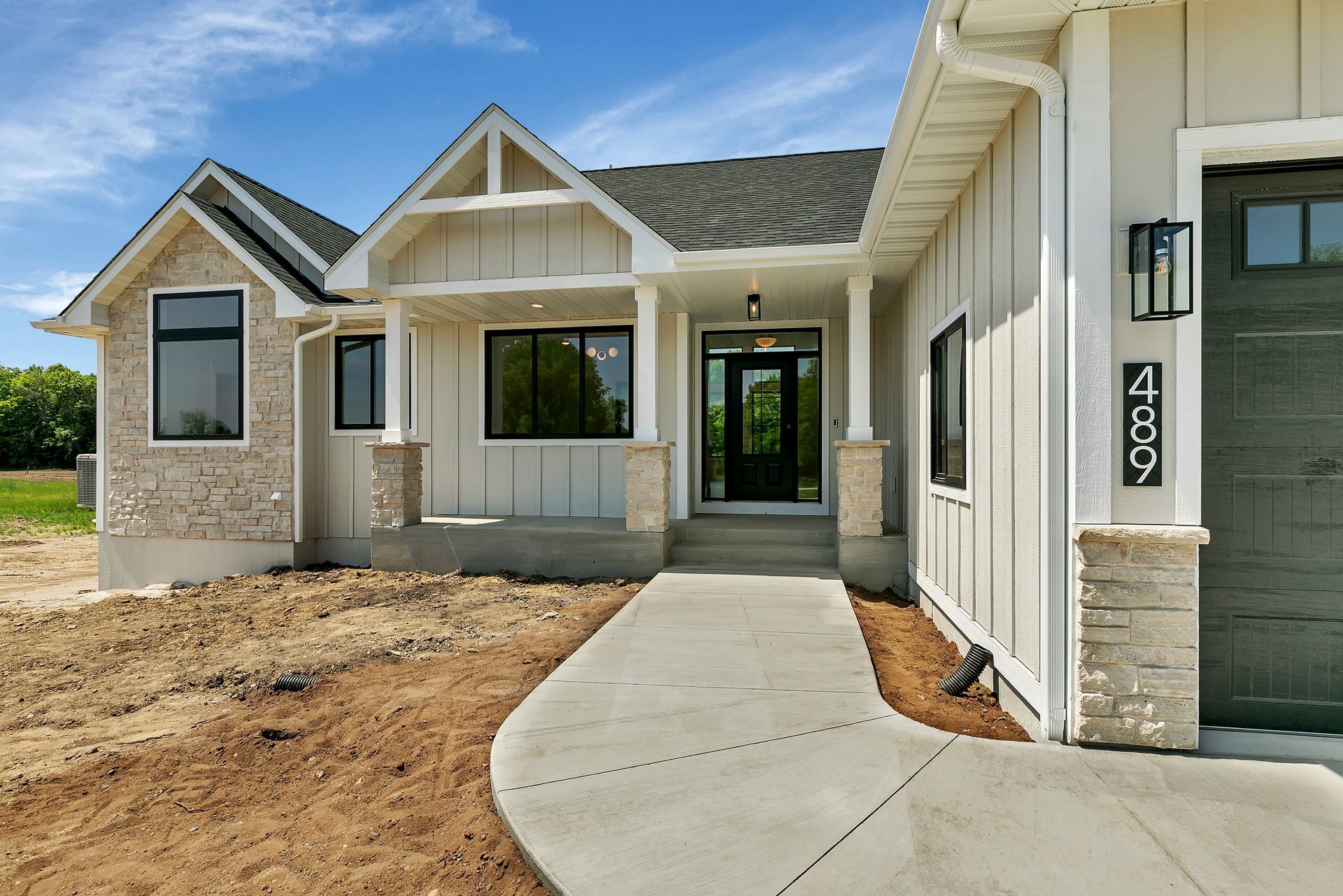 A house with a concrete walkway leading to the front door