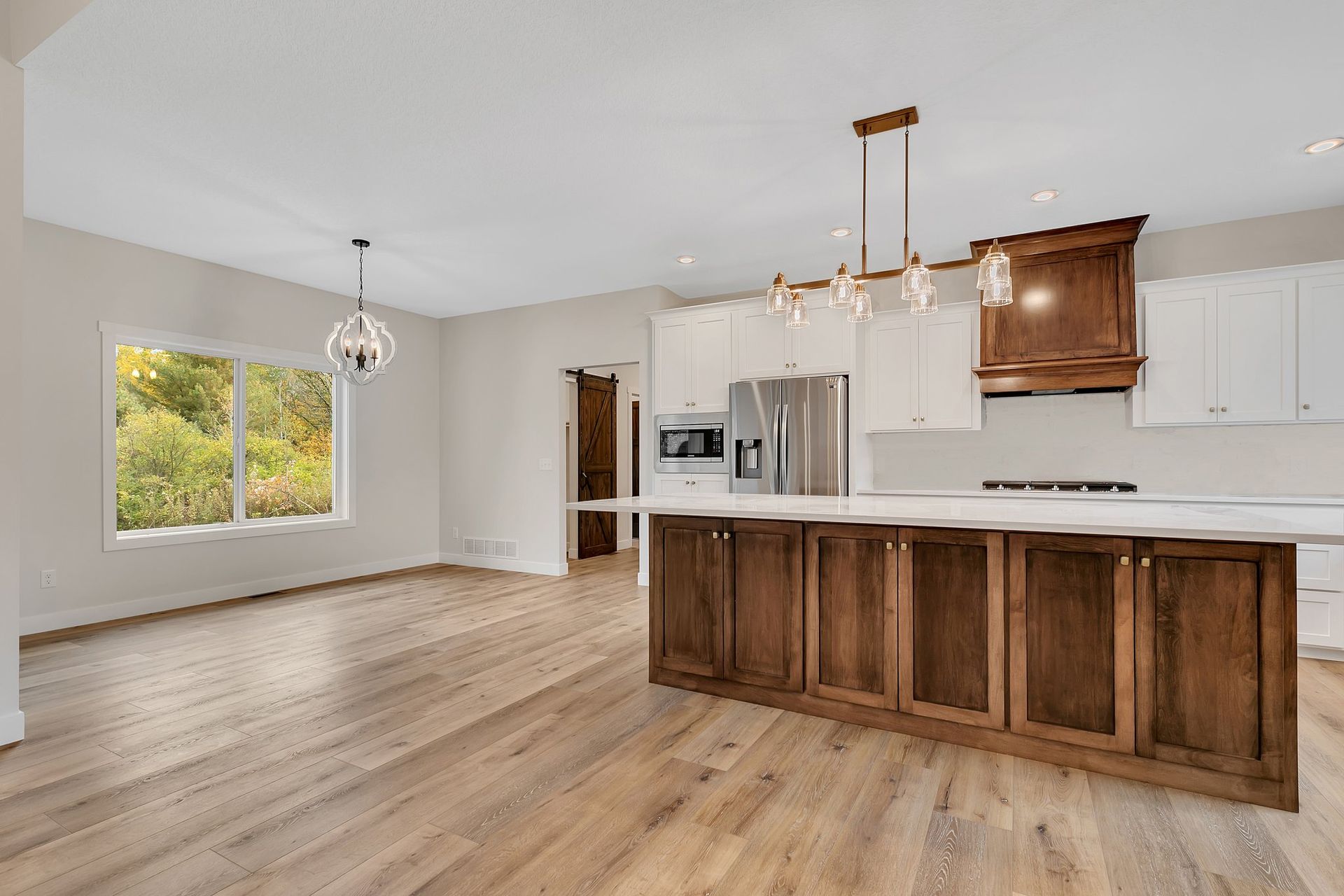 An empty kitchen with wooden cabinets and a large island.
