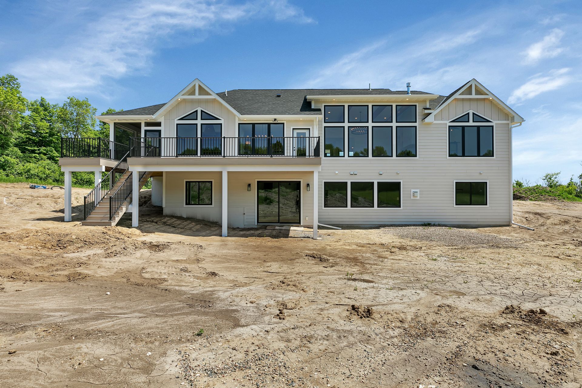 A large white house is sitting on top of a dirt hill.