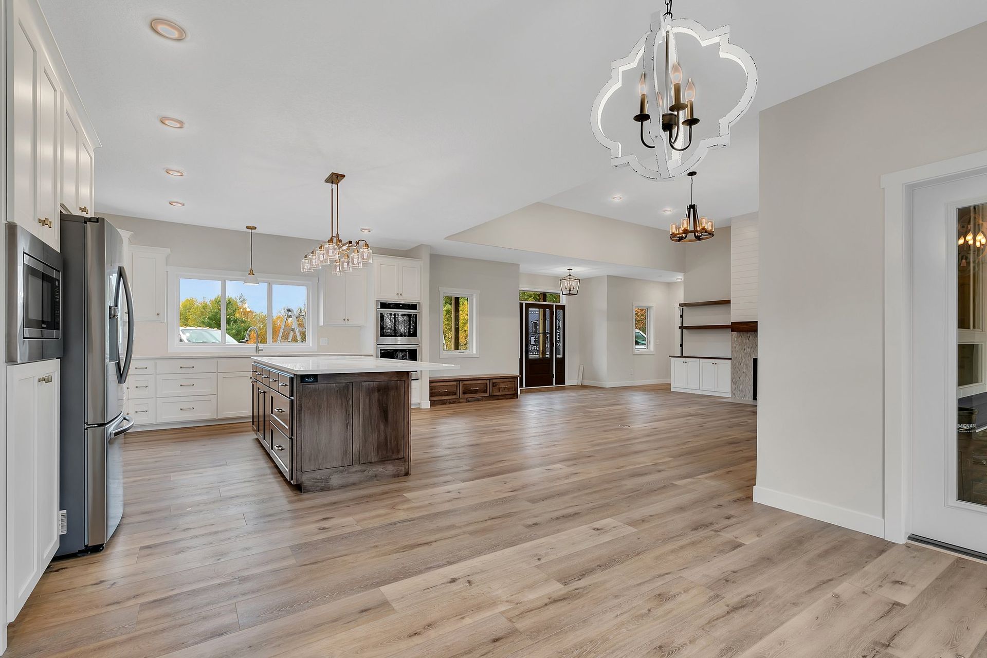 A kitchen with hardwood floors and a large island in the middle of the room.
