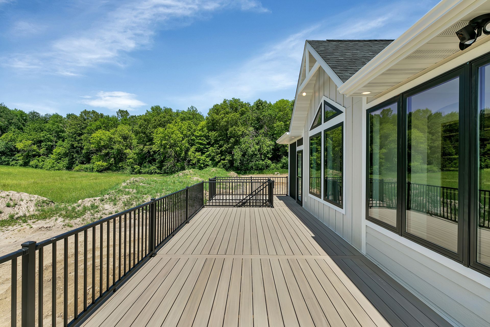 A large house with a large deck and lots of windows