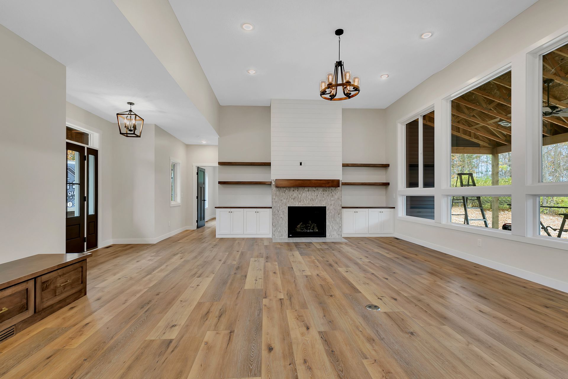 An empty living room with hardwood floors and a fireplace.