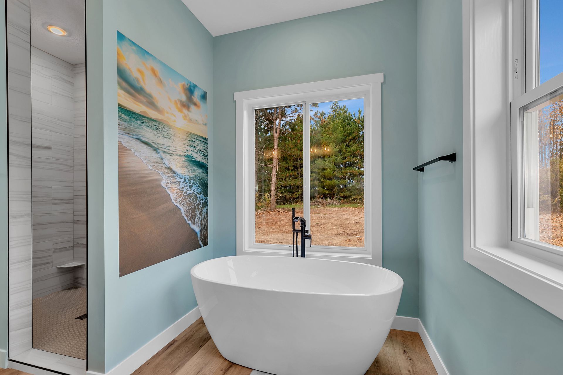 A bathroom with a bathtub and a large painting on the wall.