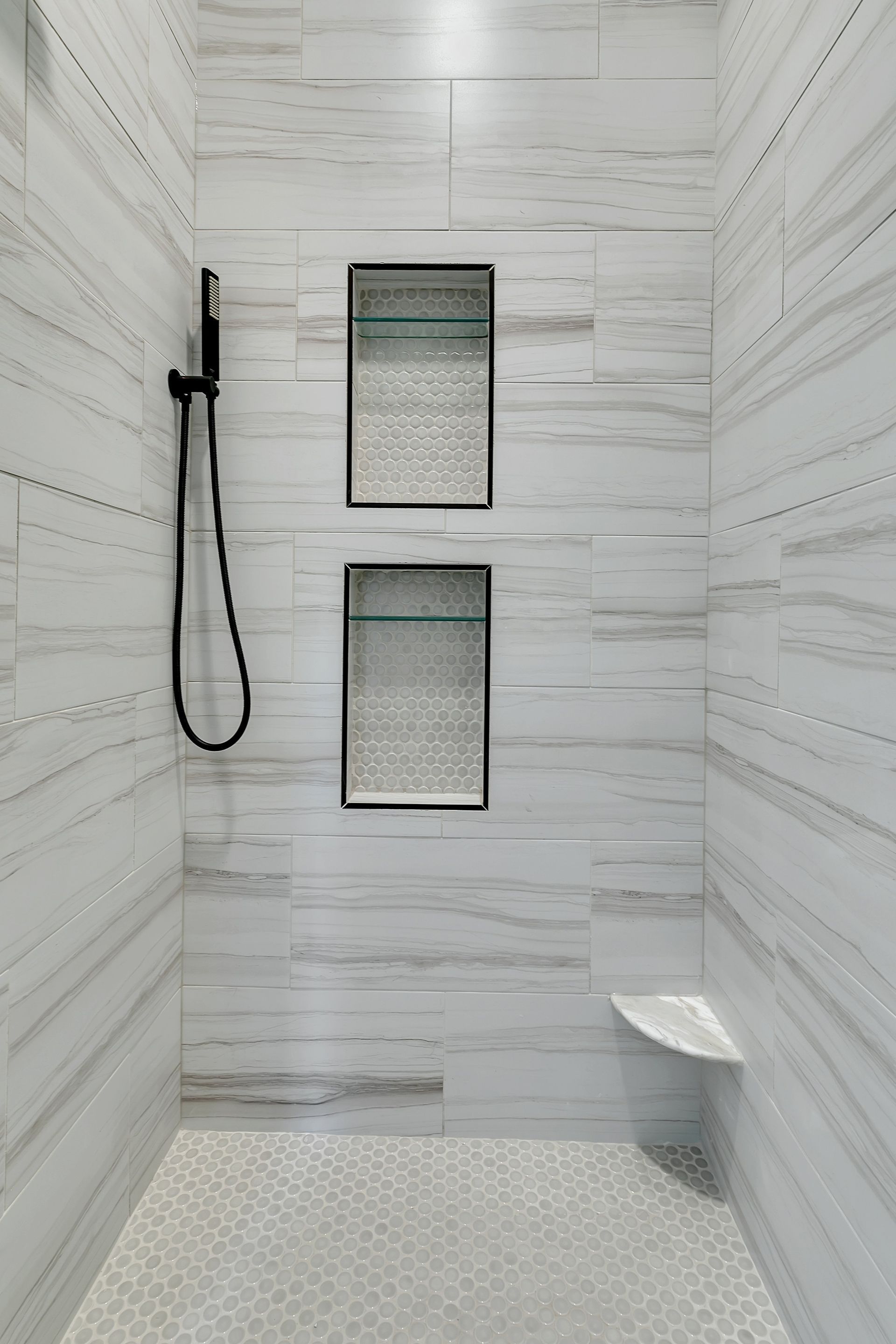 A bathroom with a walk in shower and two shelves.
