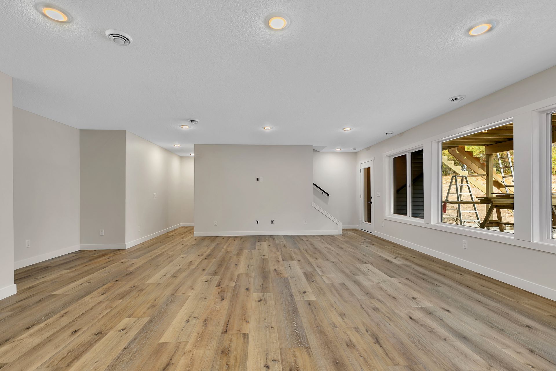 A large empty room with hardwood floors and white walls.