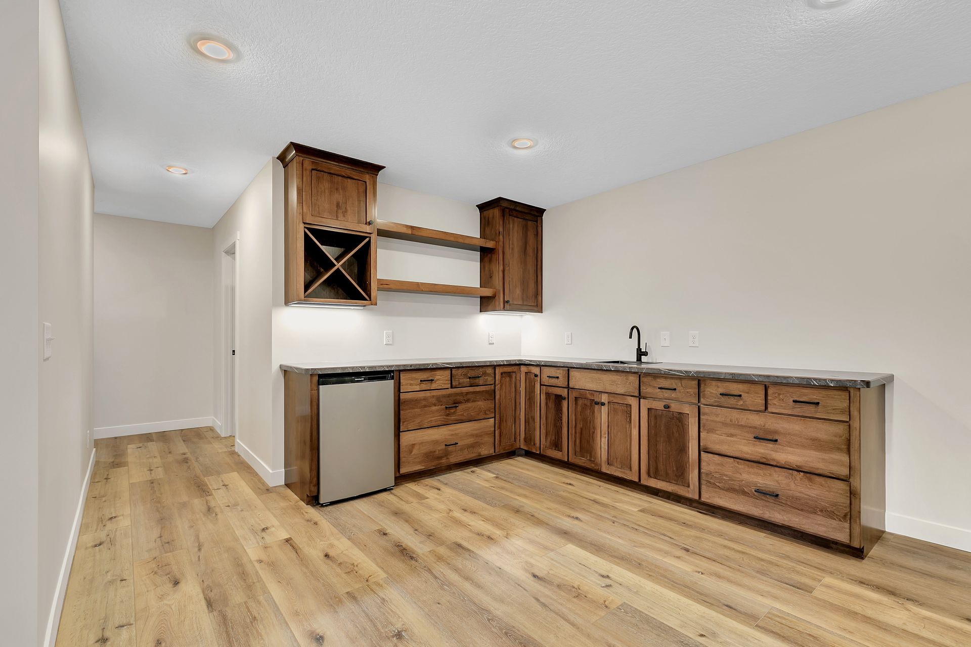 A kitchen with wooden cabinets , a sink , and a dishwasher.