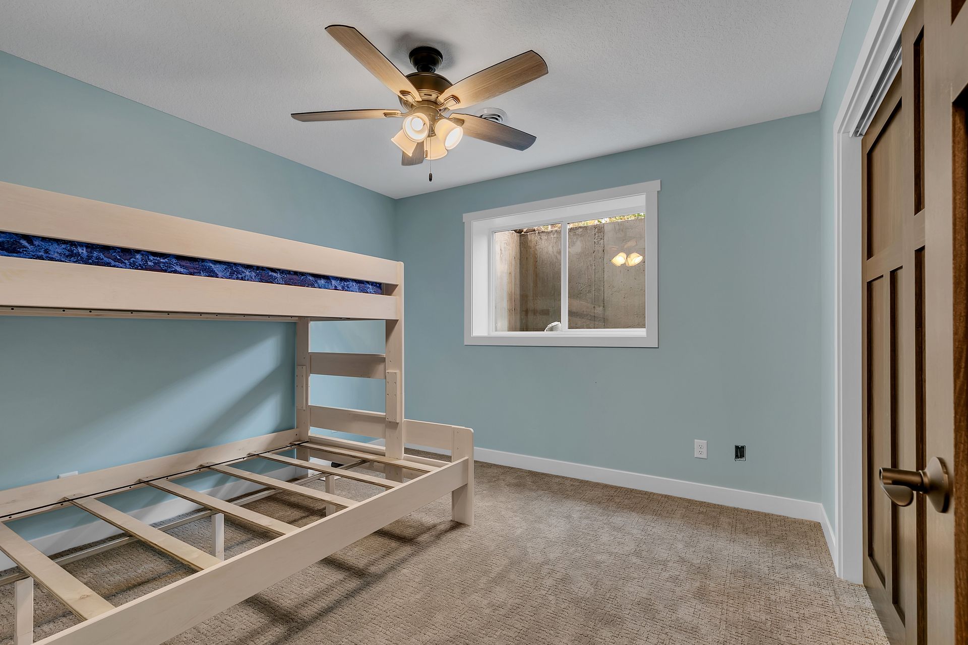 A bedroom with a bunk bed and a ceiling fan.