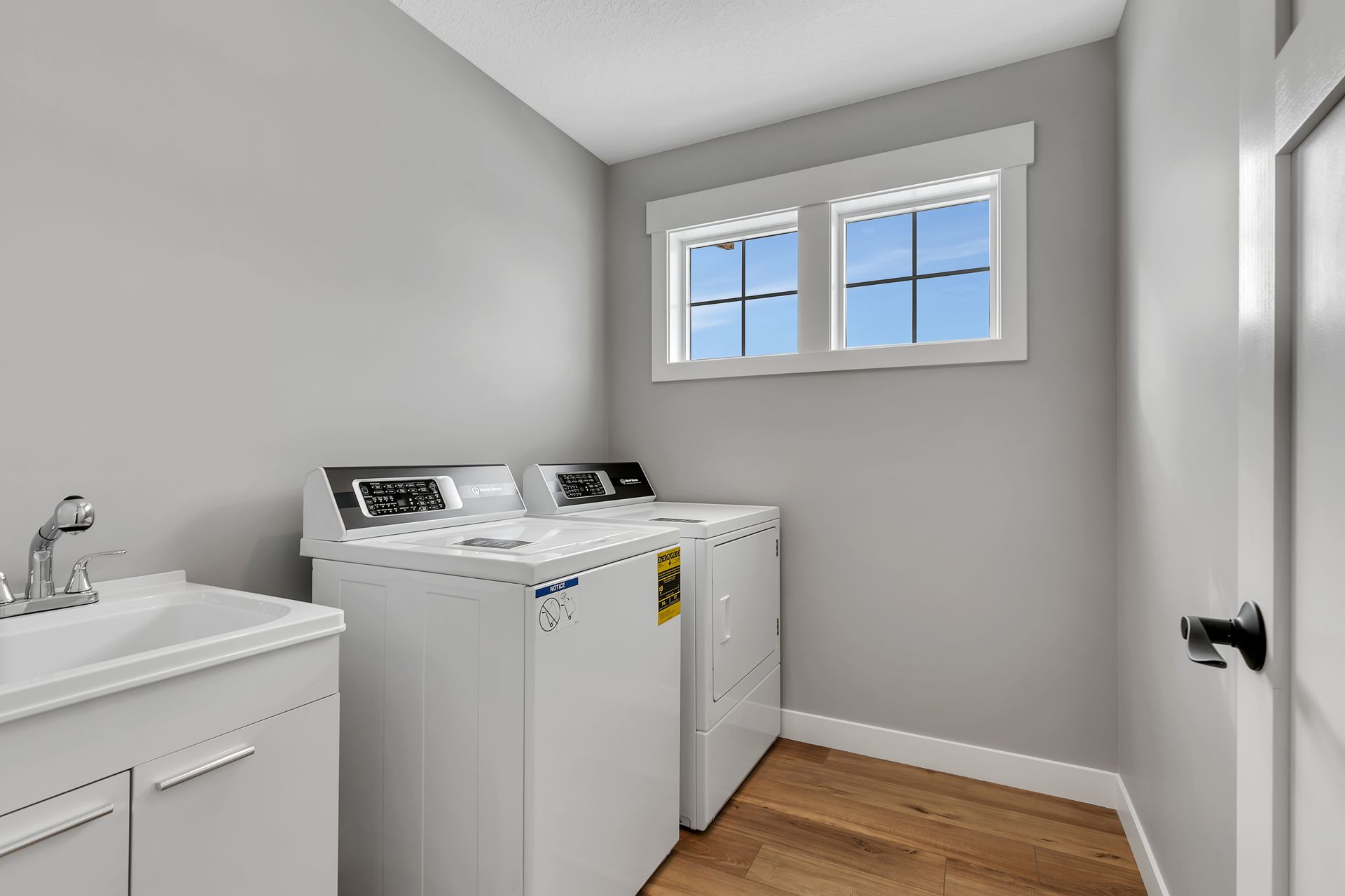 A laundry room with a washer and dryer and a sink.