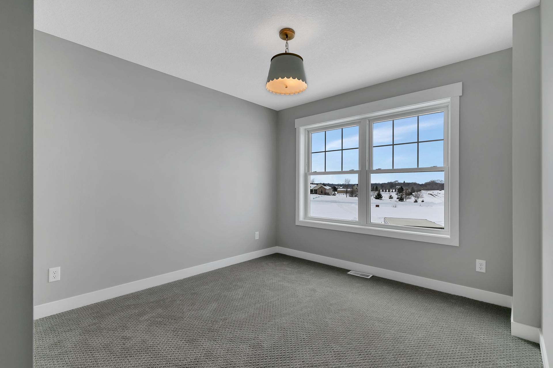 An empty room with two windows and a ceiling light.