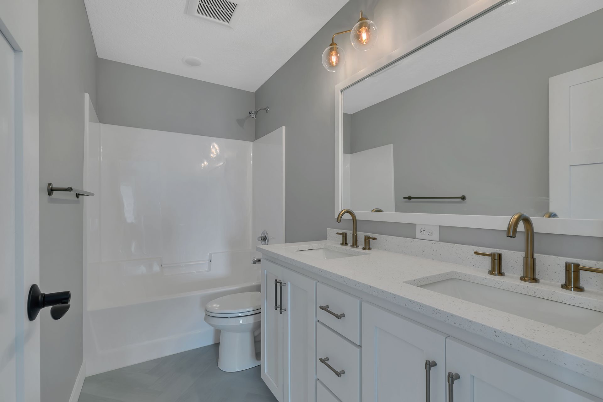 A bathroom with two sinks , a toilet , and a bathtub.
