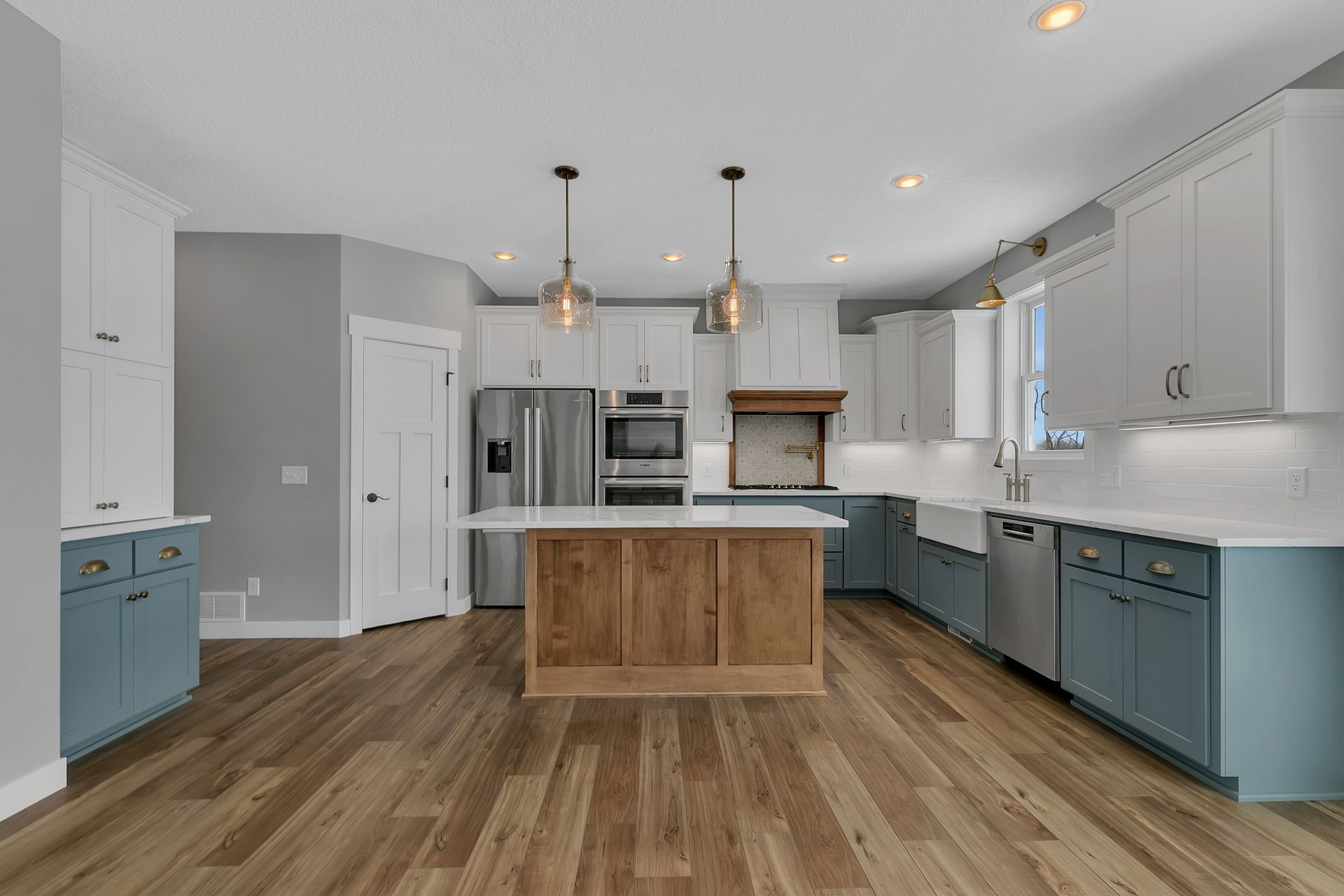 A kitchen with stainless steel appliances and wooden floors.