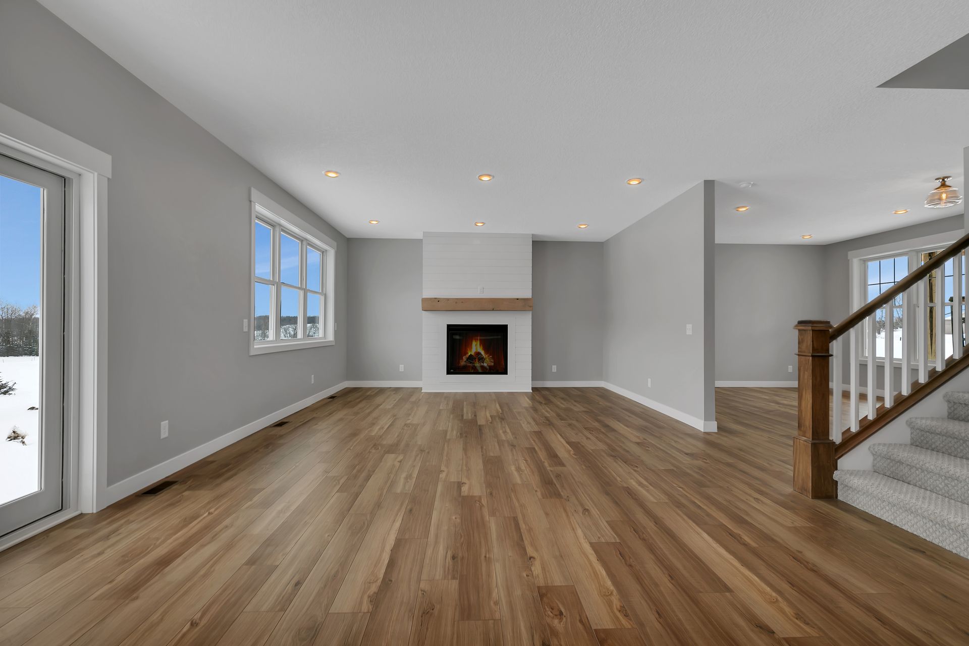 An empty living room with hardwood floors and a fireplace.