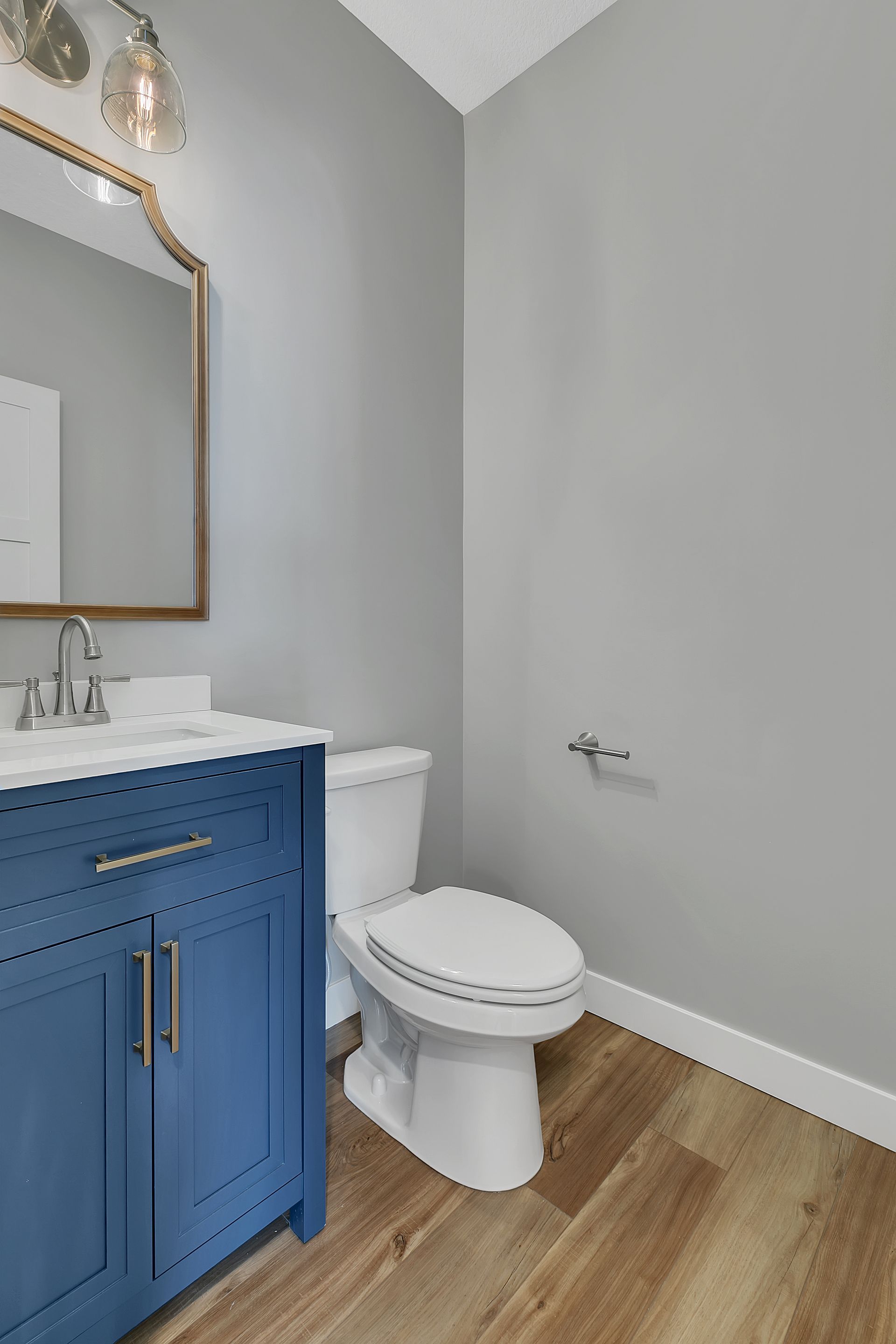A bathroom with a toilet , sink and mirror.