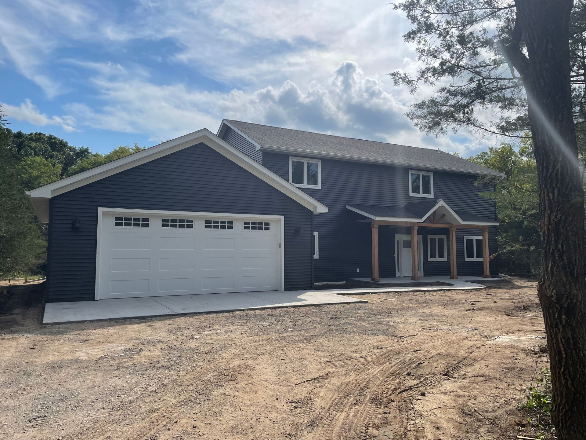 A large house with a garage and a tree in front of it