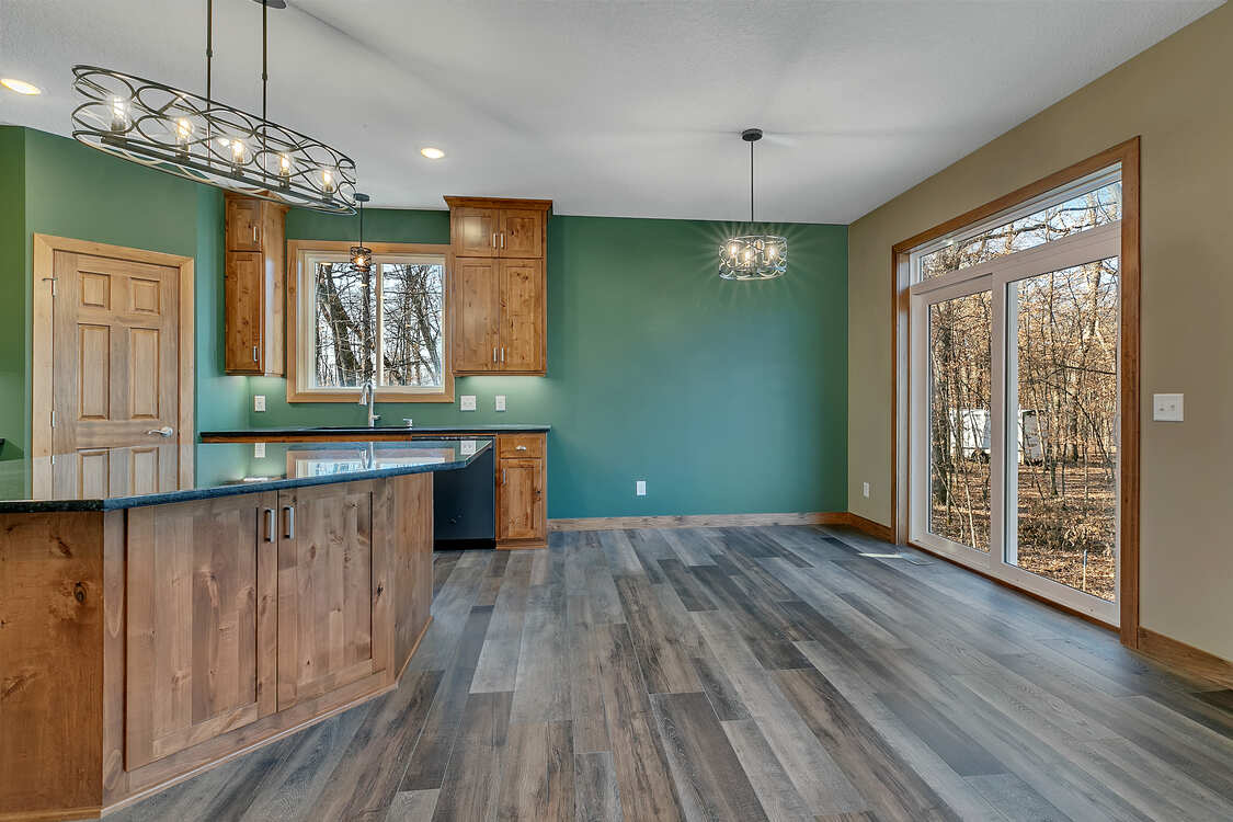 A kitchen with wooden cabinets and sliding glass doors.