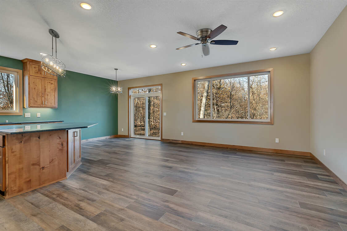 An empty living room with hardwood floors and a ceiling fan.
