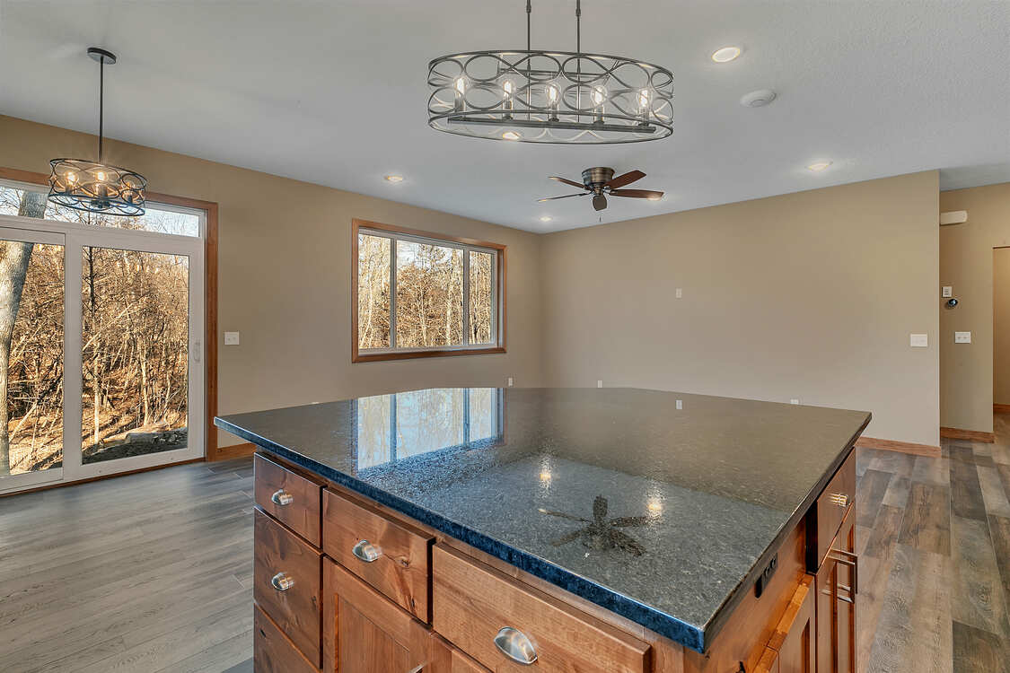 A kitchen with a large island and a ceiling fan.