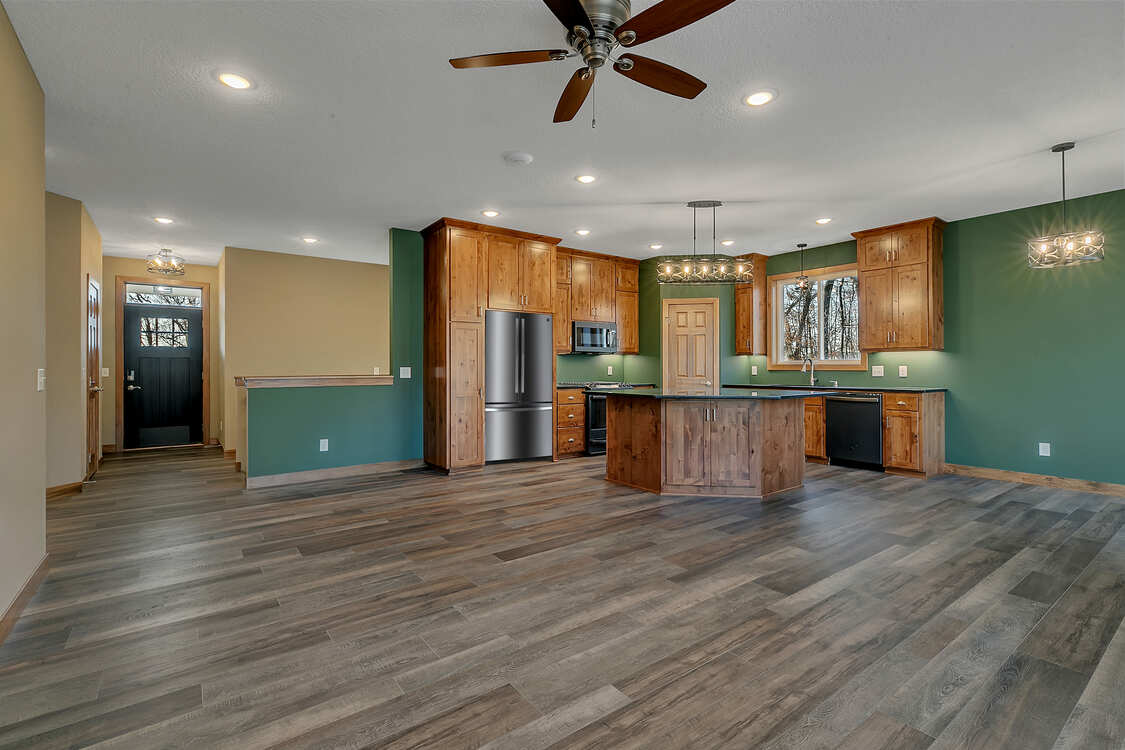A kitchen with wooden cabinets and a ceiling fan.