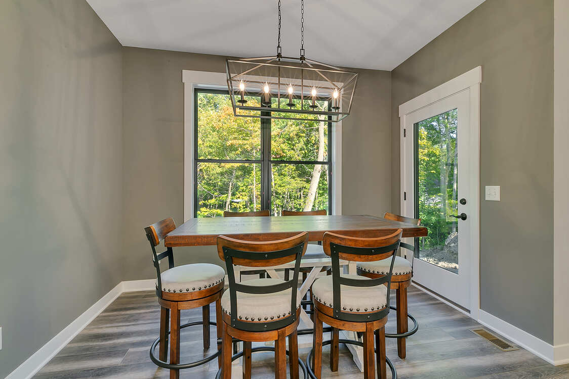 A dining room with a table and chairs and a chandelier.
