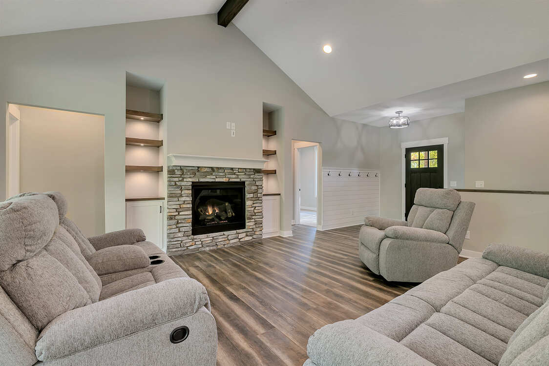 A living room with two couches and a fireplace.