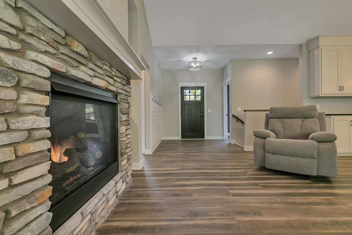 A living room with a fireplace and a chair.