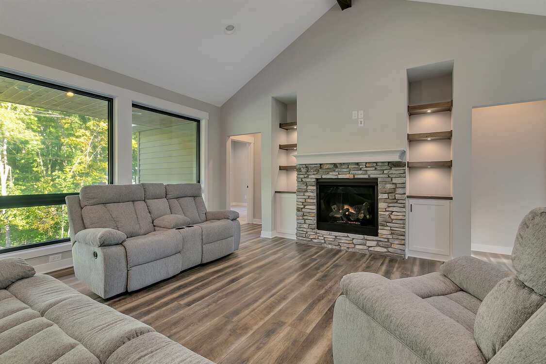A living room with a couch and chairs and a fireplace.