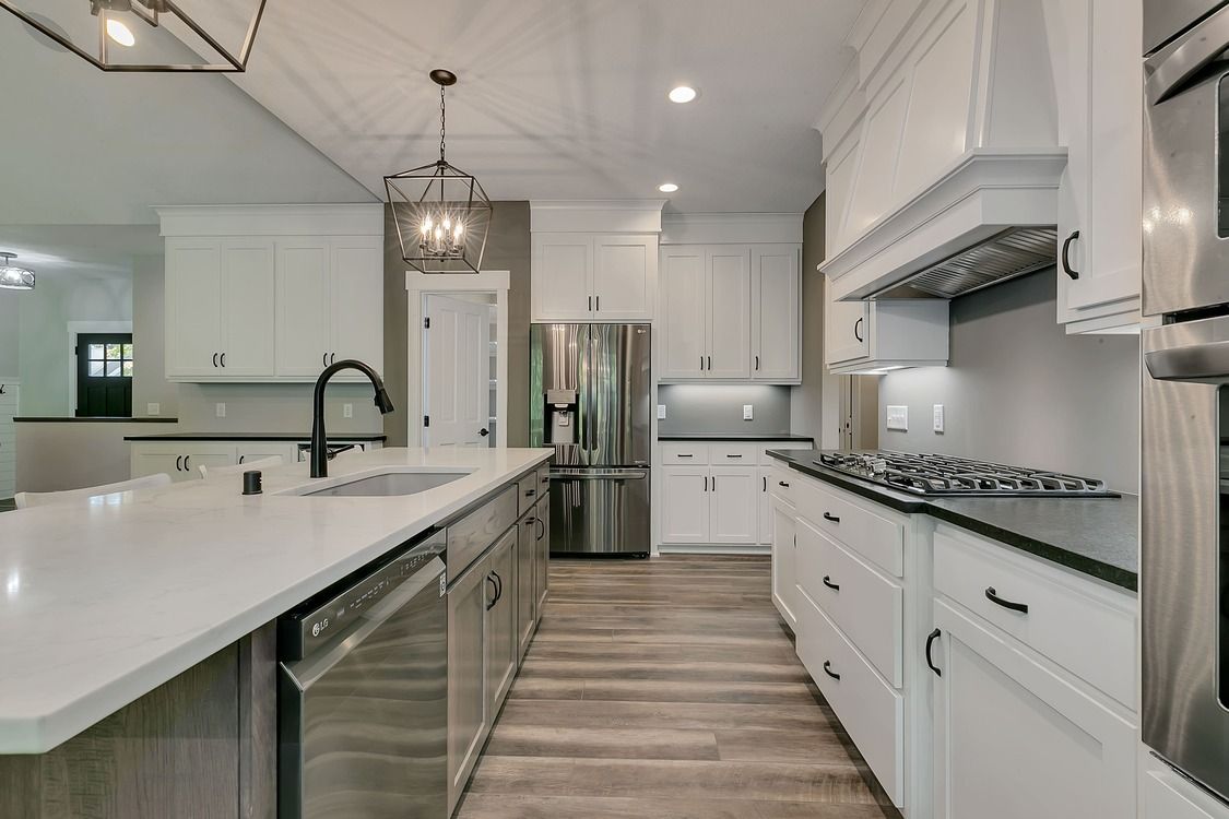 A kitchen with white cabinets and stainless steel appliances.