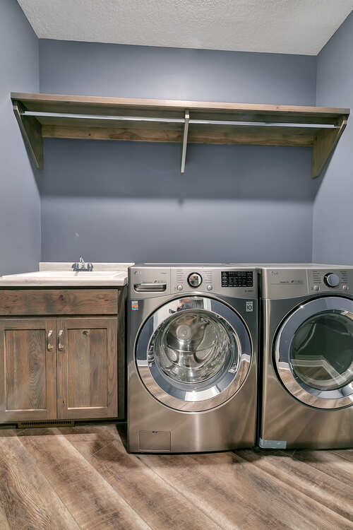 A laundry room with a washer and dryer and a sink.