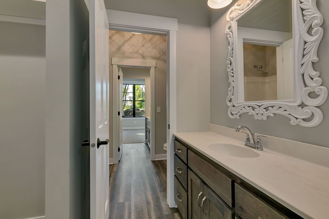 A bathroom with a sink , mirror and cabinets.
