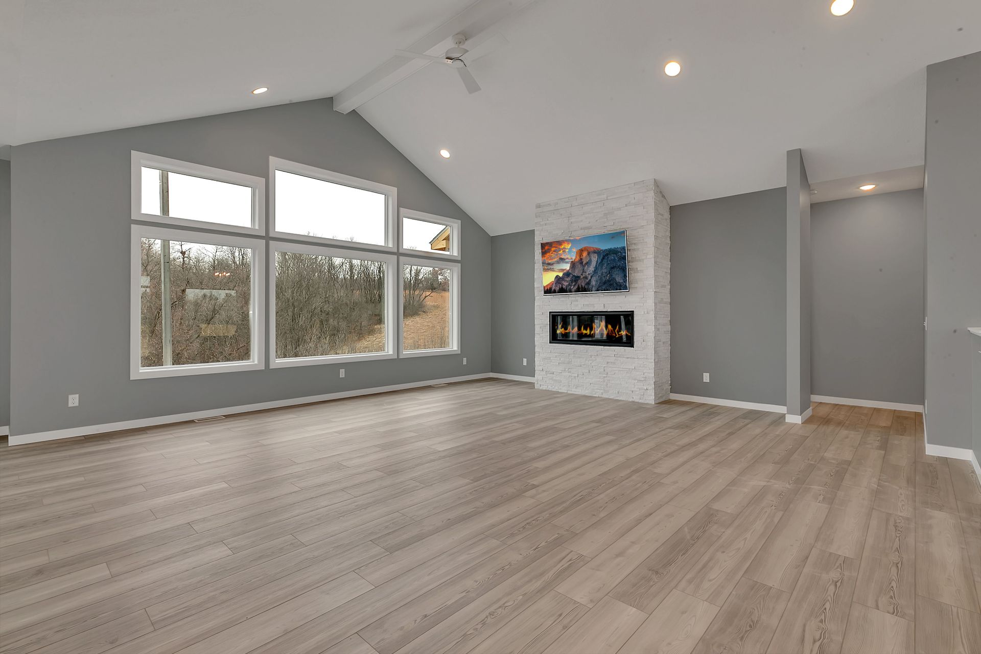 An empty living room with hardwood floors and a fireplace.