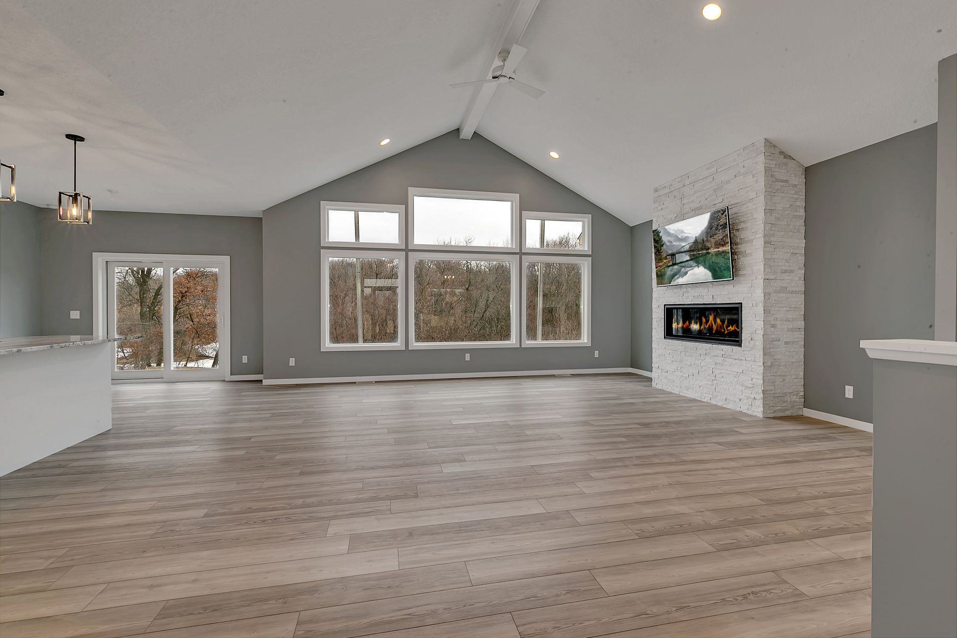 An empty living room with hardwood floors and a fireplace.