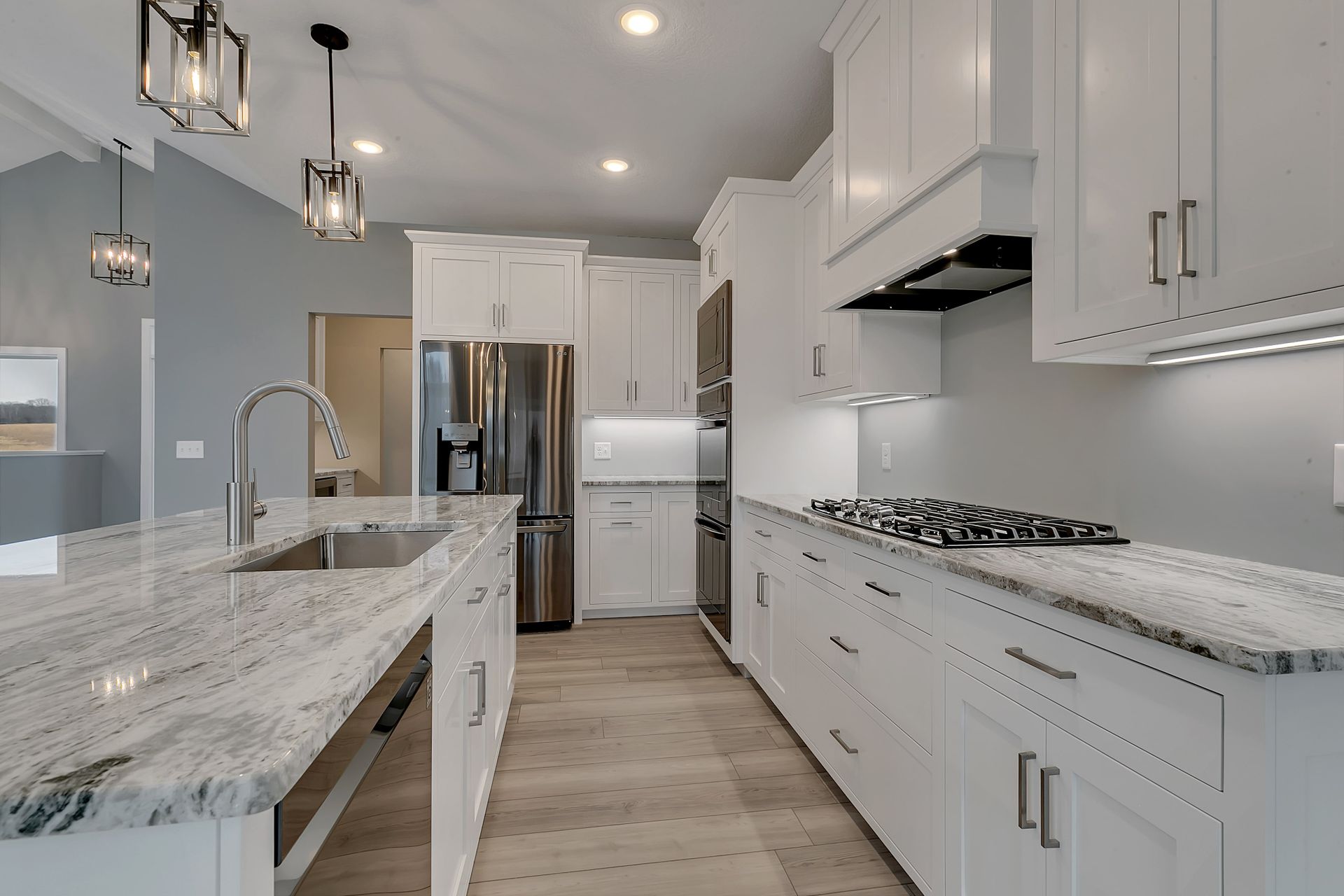 A kitchen with white cabinets and granite counter tops.