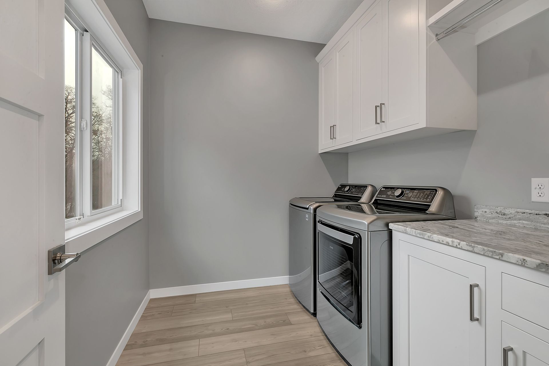 A laundry room with a washer and dryer and a window.