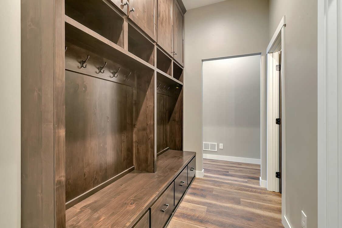 A hallway with wooden cabinets and drawers in a house.